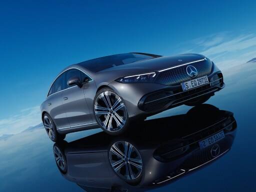 The all-electric EQS from Mercedes-Benz standing in its blue EQ World with mirroring floor surface.
