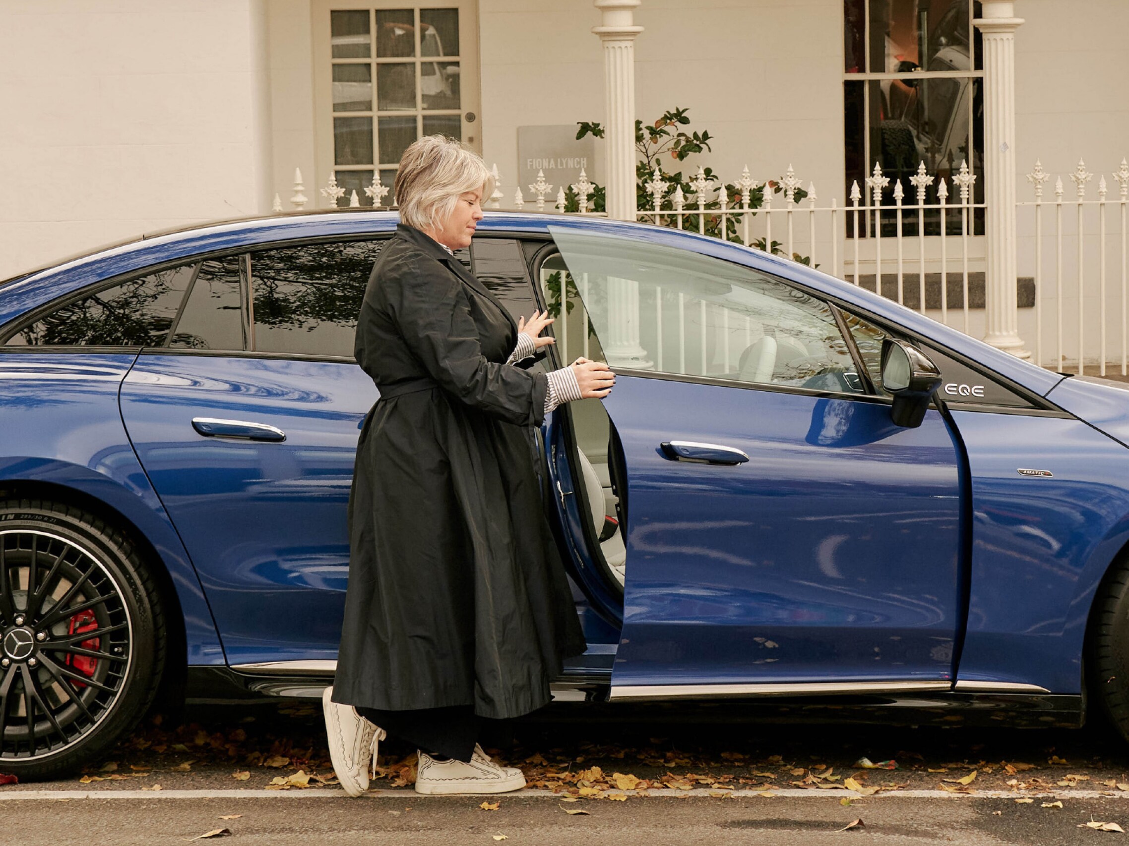 Fiona Lynch opening the door to a Spectral Blue Mercedes-AMG EQE 53 4MATIC. Image credit/photographer: Sam Wong