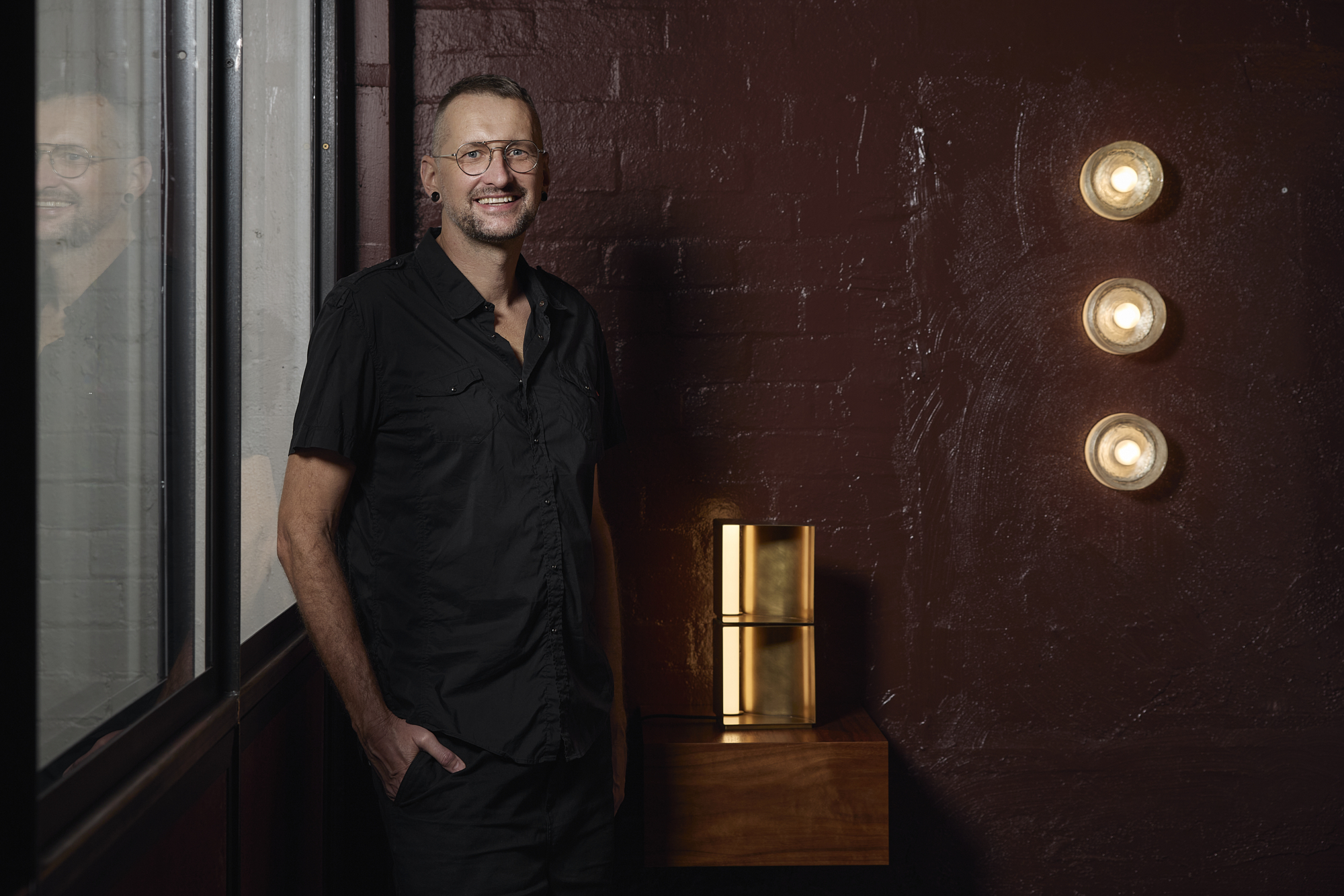 Volker Haug smiling next to own lighting design. Volker Haug smiling next to own lighting design.