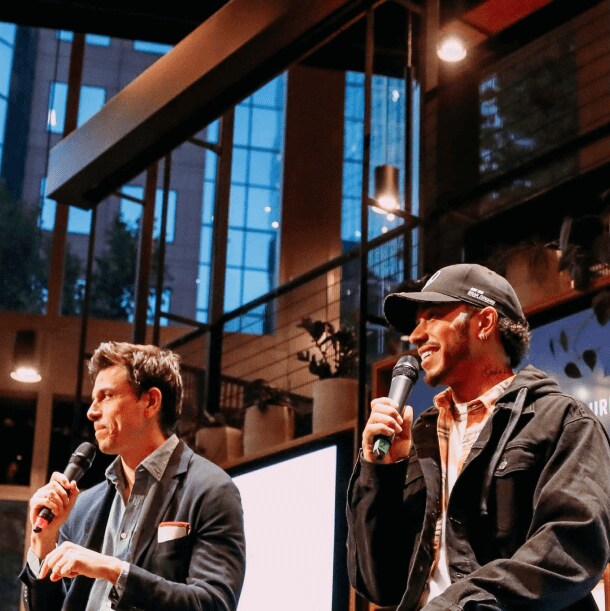 Toto Wolff and Lewis Hamilton on stage with Tom Clarkson