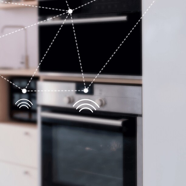 Someone holding a mobile phone to control smart devices in their kitchen