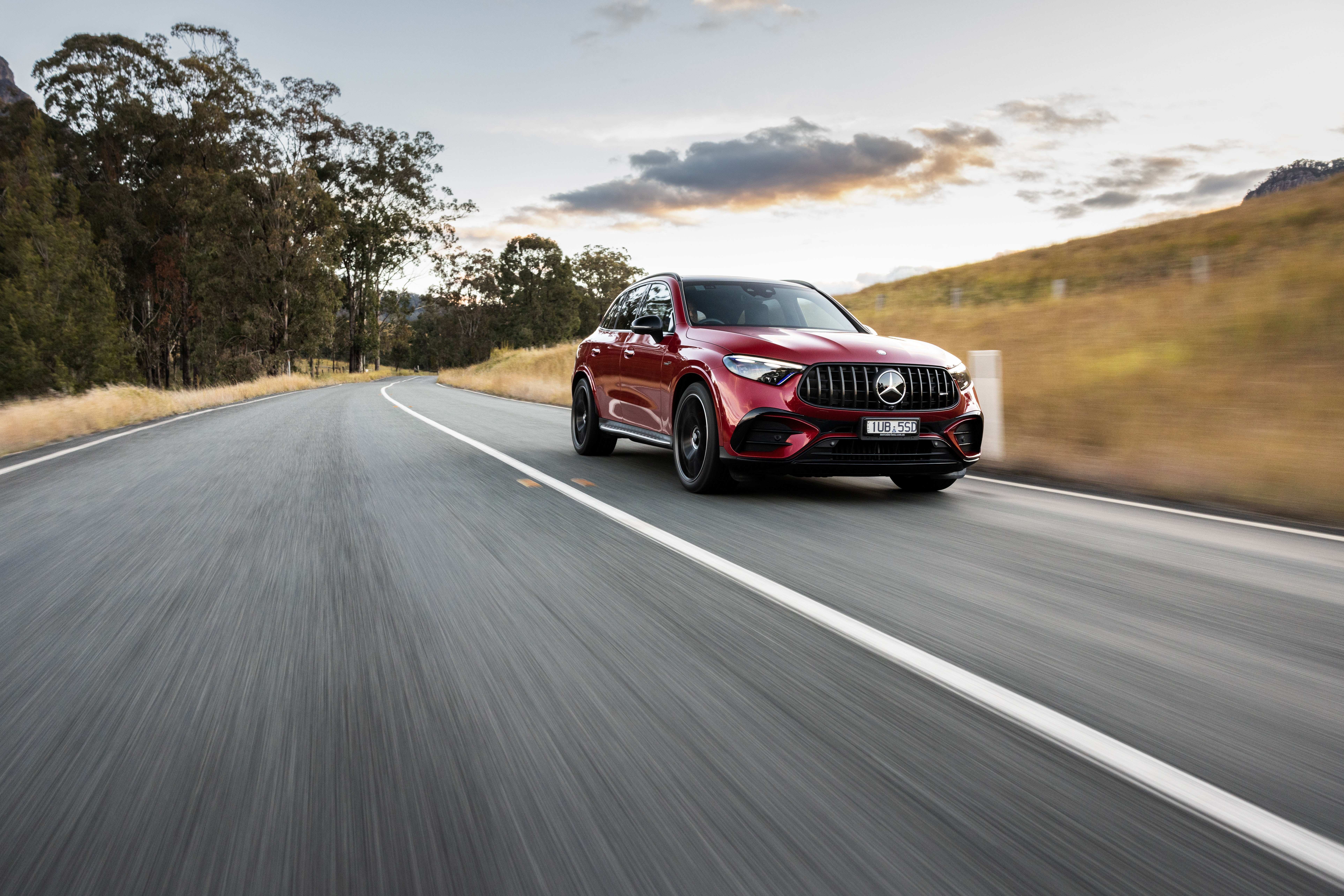 Red Mercedes-AMG C 63 S E PERFORMANCE driving on the road. Red Mercedes-AMG C 63 S E PERFORMANCE driving on the road.