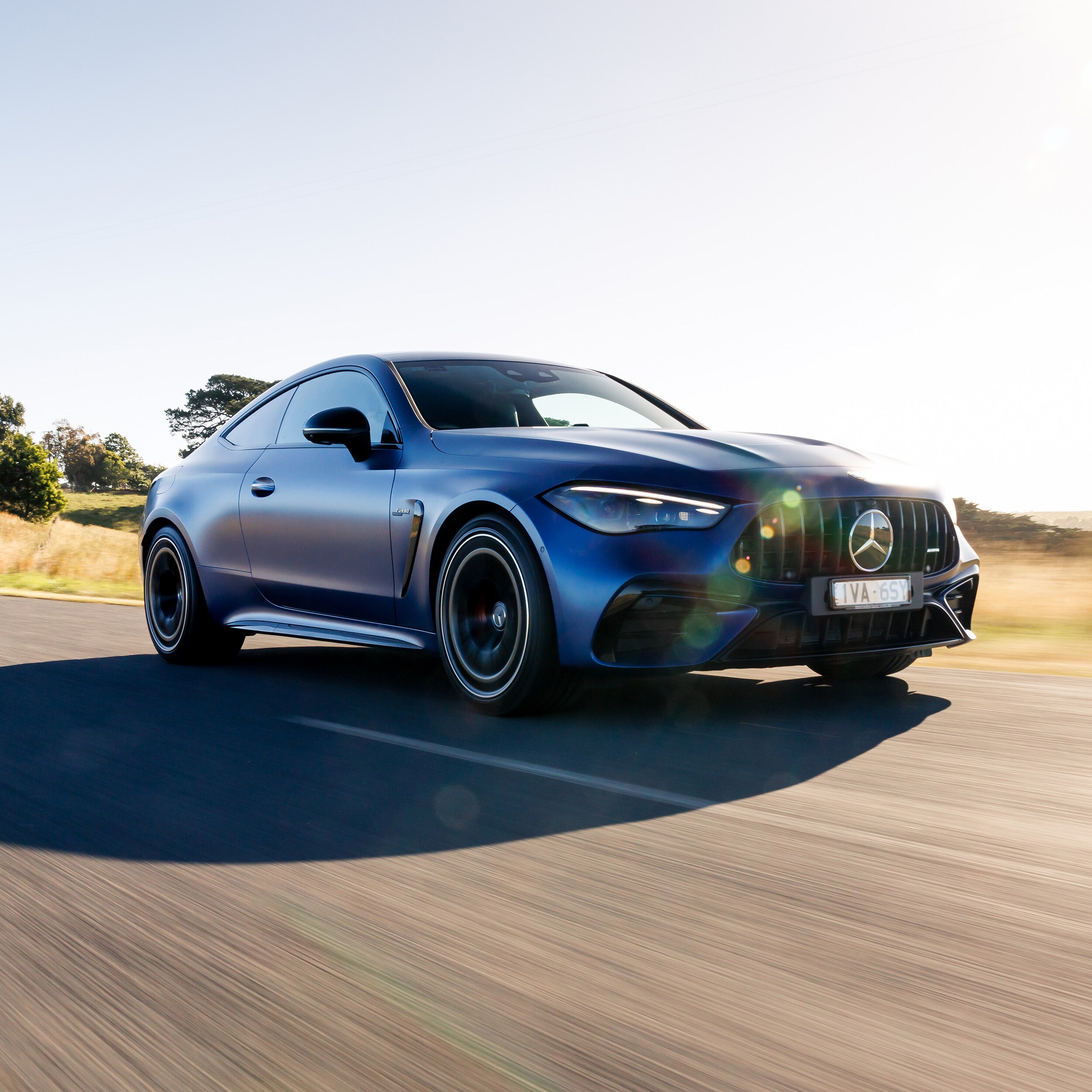 Blue Mercedes-AMG CLE 53 4MATIC+ Coupé driving on a country road. Image credit/photographer: 