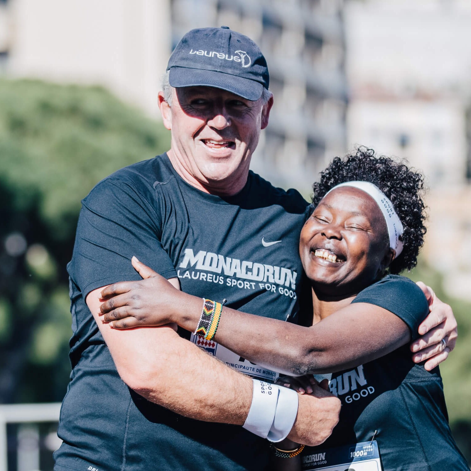 Laureus Chairman Sean Fitzpatrick hugs Laureus Academy Member Tegla Louroupe after finishing in the 1000m Sport for Good Run.