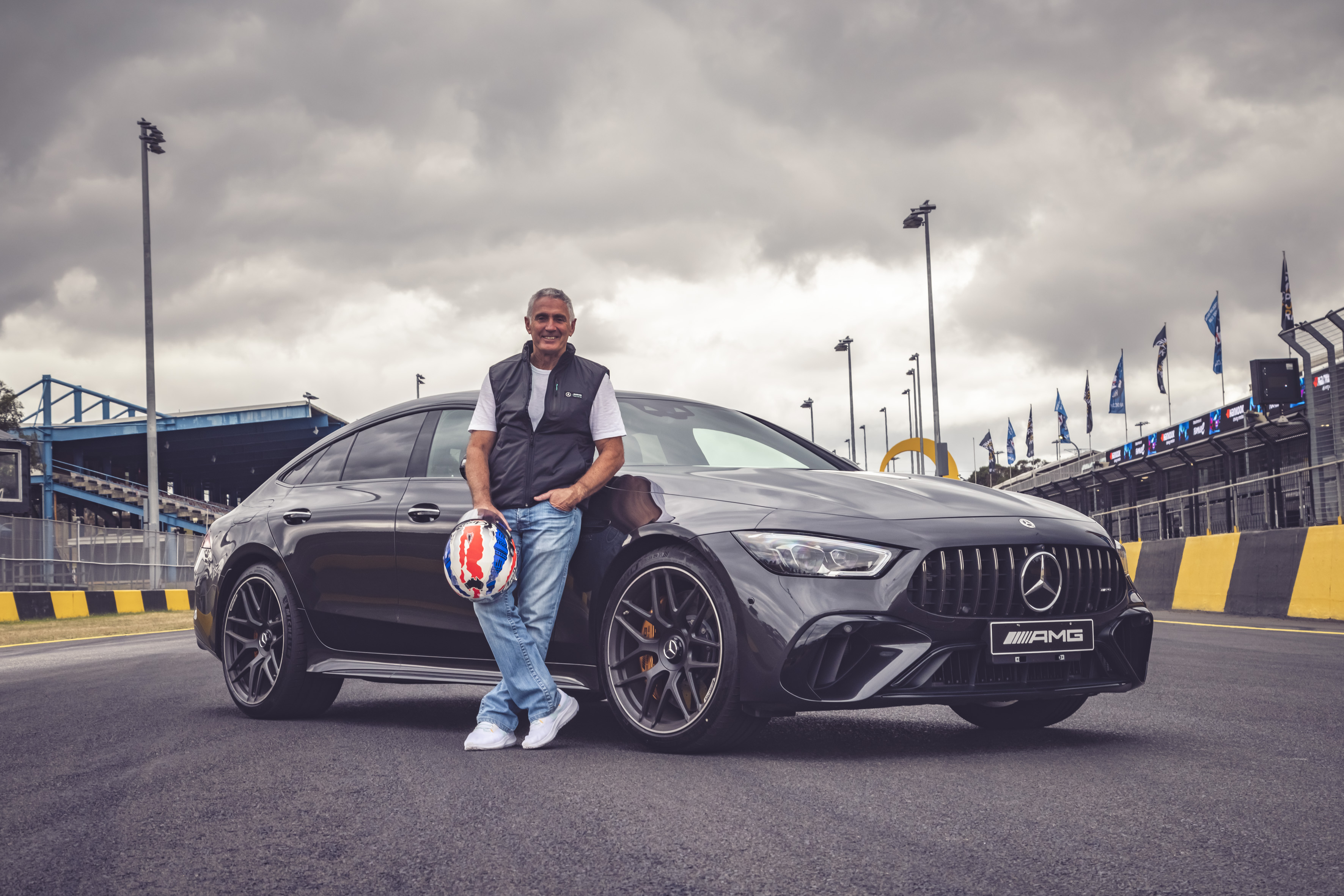 Image credit/photographer: Thomas Wielecki Mick Doohan holding motorcycle helmet standing in front of Mercedes-AMG