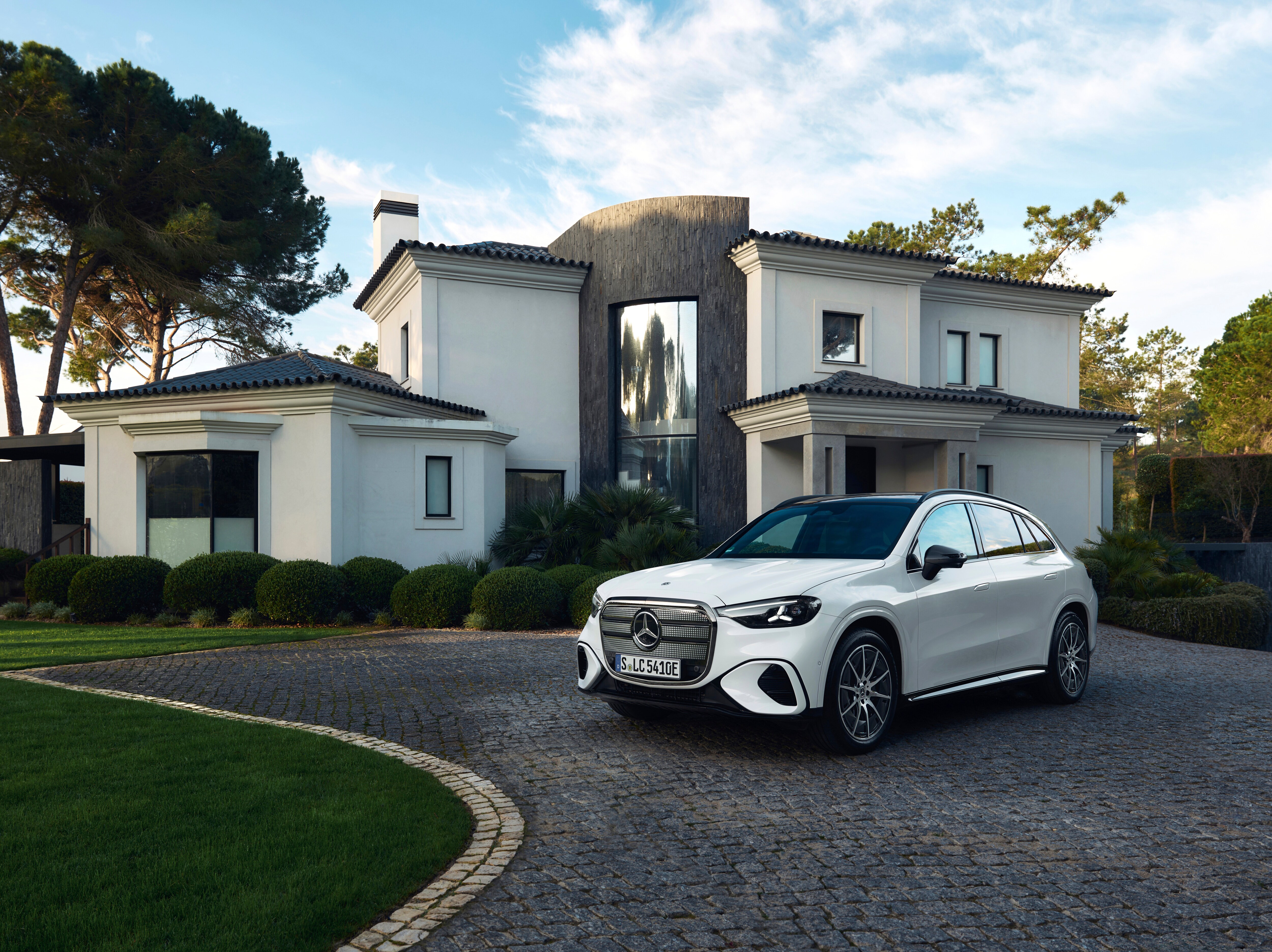A white SUV parked in the driveway of a house