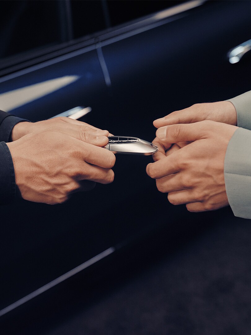 A Business Manager handing over a new set of Mercedes-Benz keys to a customer.