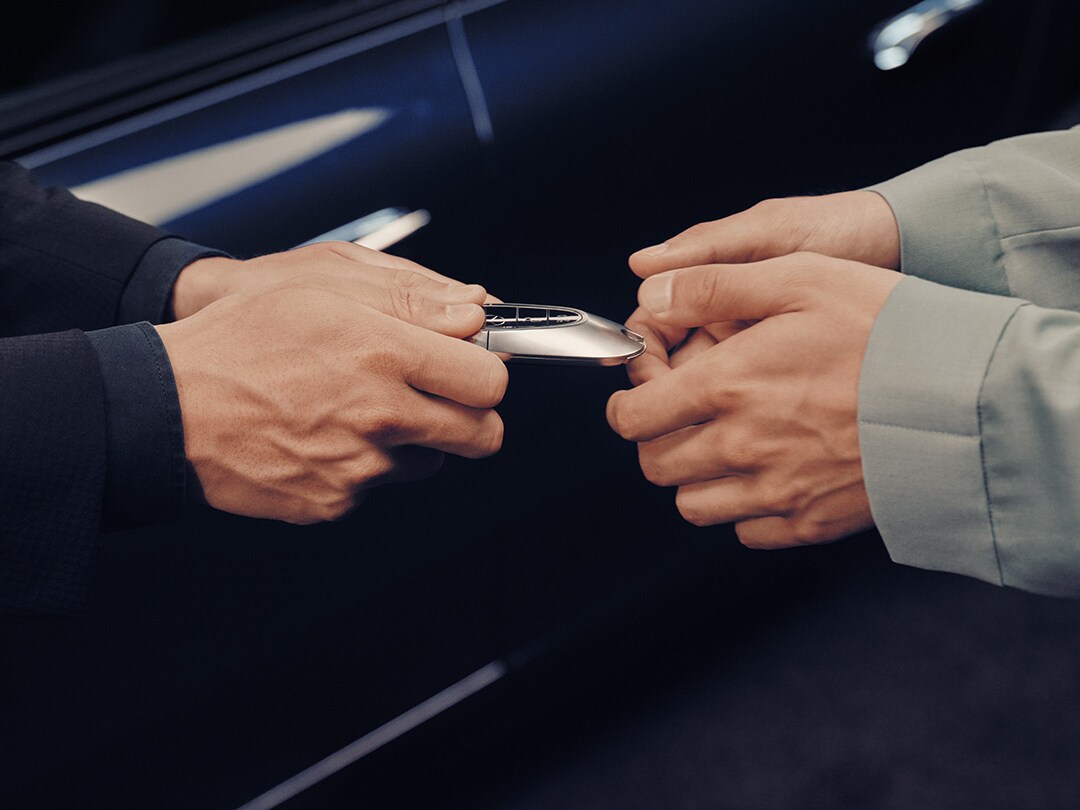 A Business Manager handing over a new set of Mercedes-Benz keys to a customer.