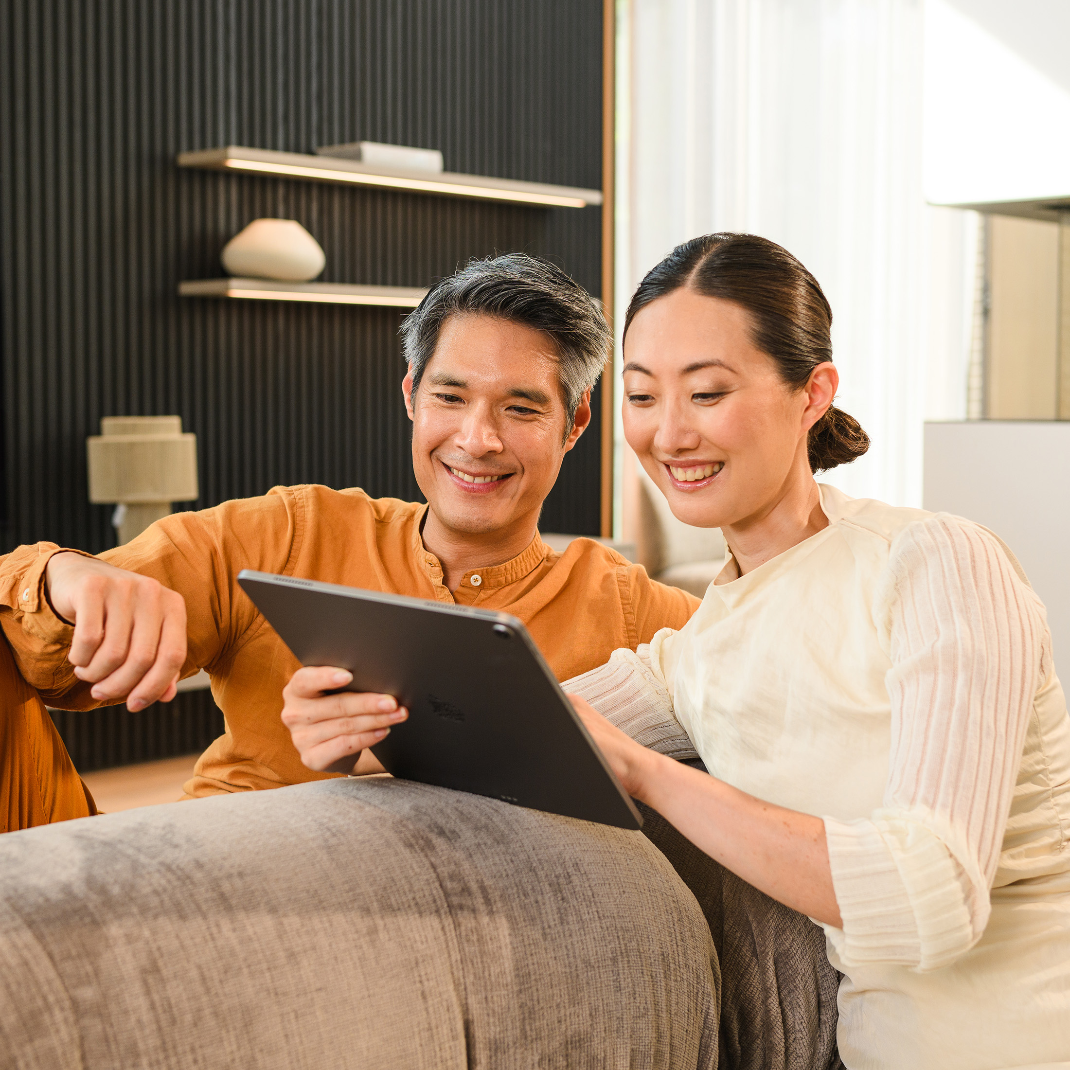 Two people on a sofa looking at a mobile device. Two people on a sofa looking at a mobile device.