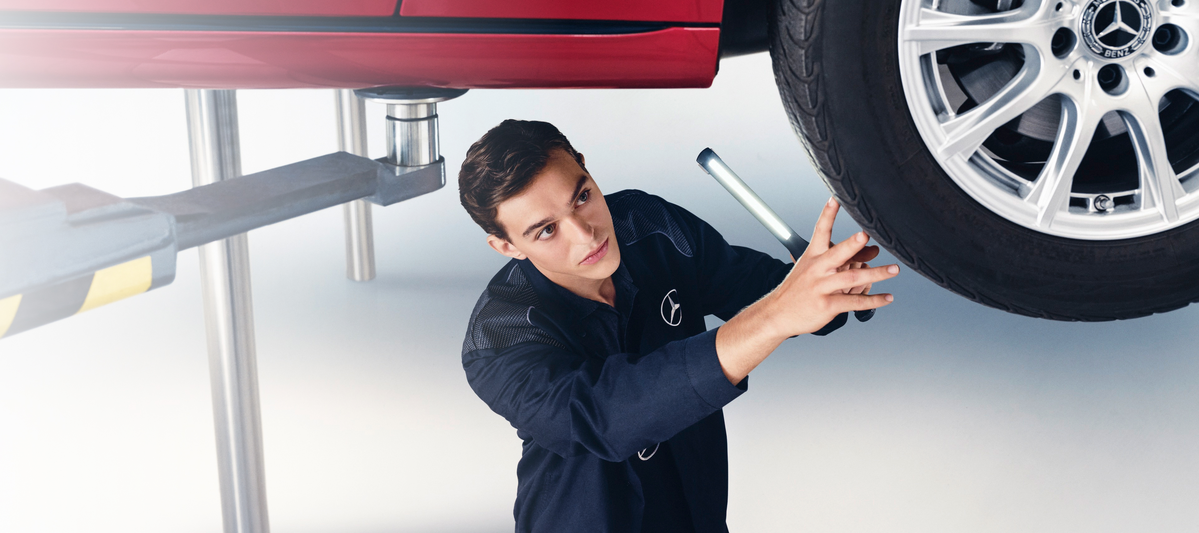 Maintenance Services | Mercedes-Benz A Mercedes-Benz mechanic examines the wheel of a Mercedes-Benz.