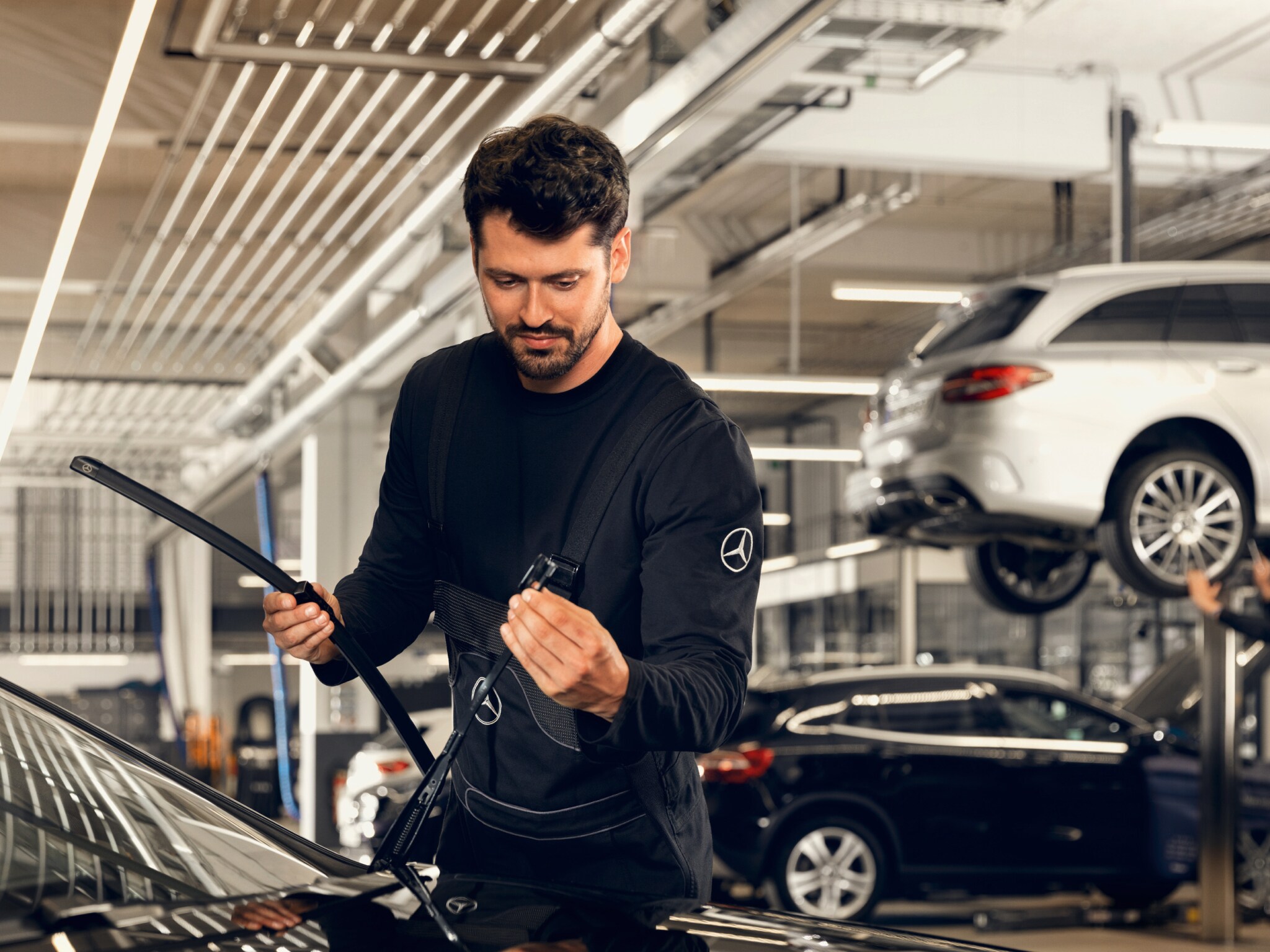 A technician checks the windshield of a Mercedes-Benz.