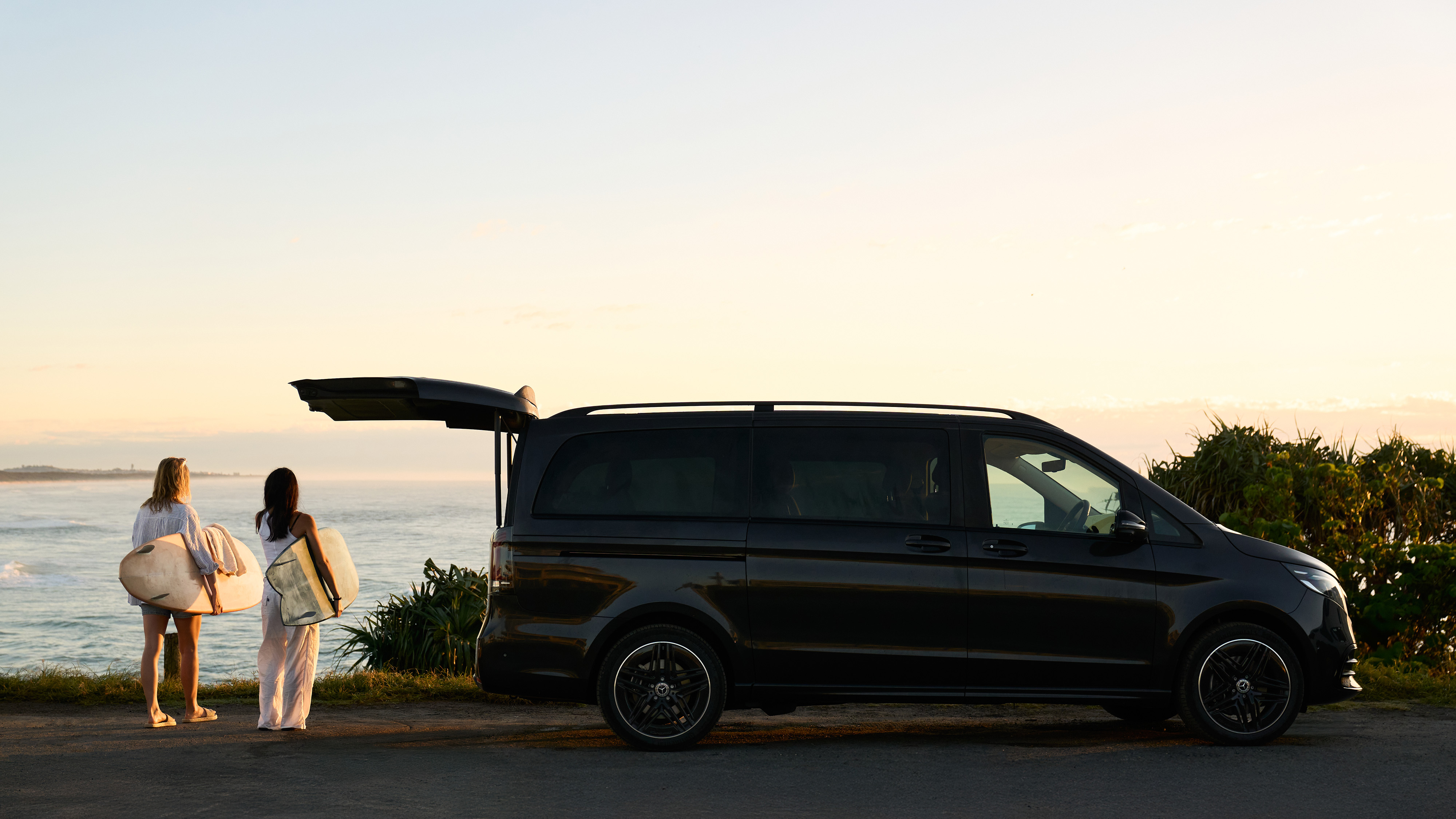 Two women with surfboards walking by beach. Two women with surfboards walking by beach.