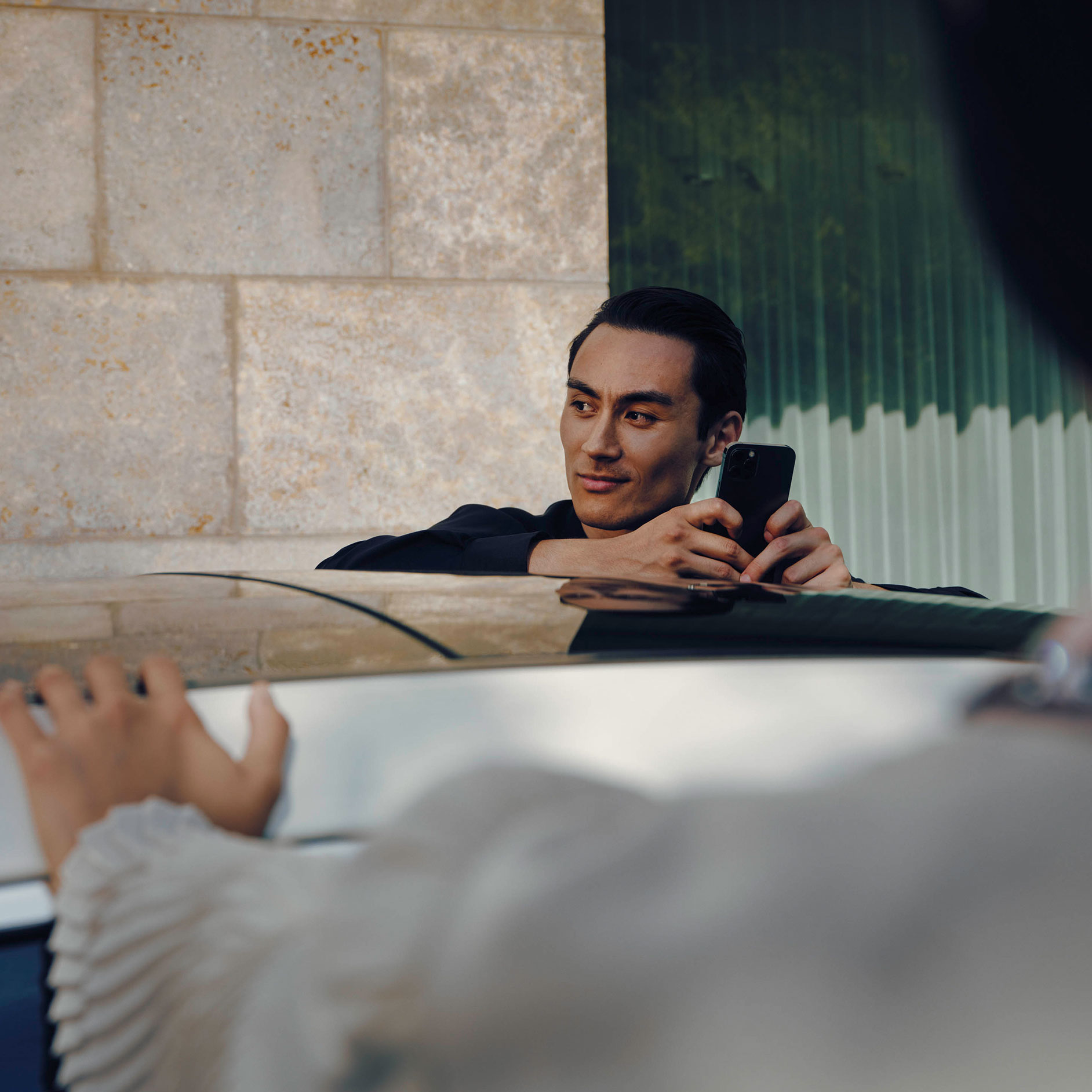 Agility Loan Program Man holding mobile phone on white Mercedes Benz EQS