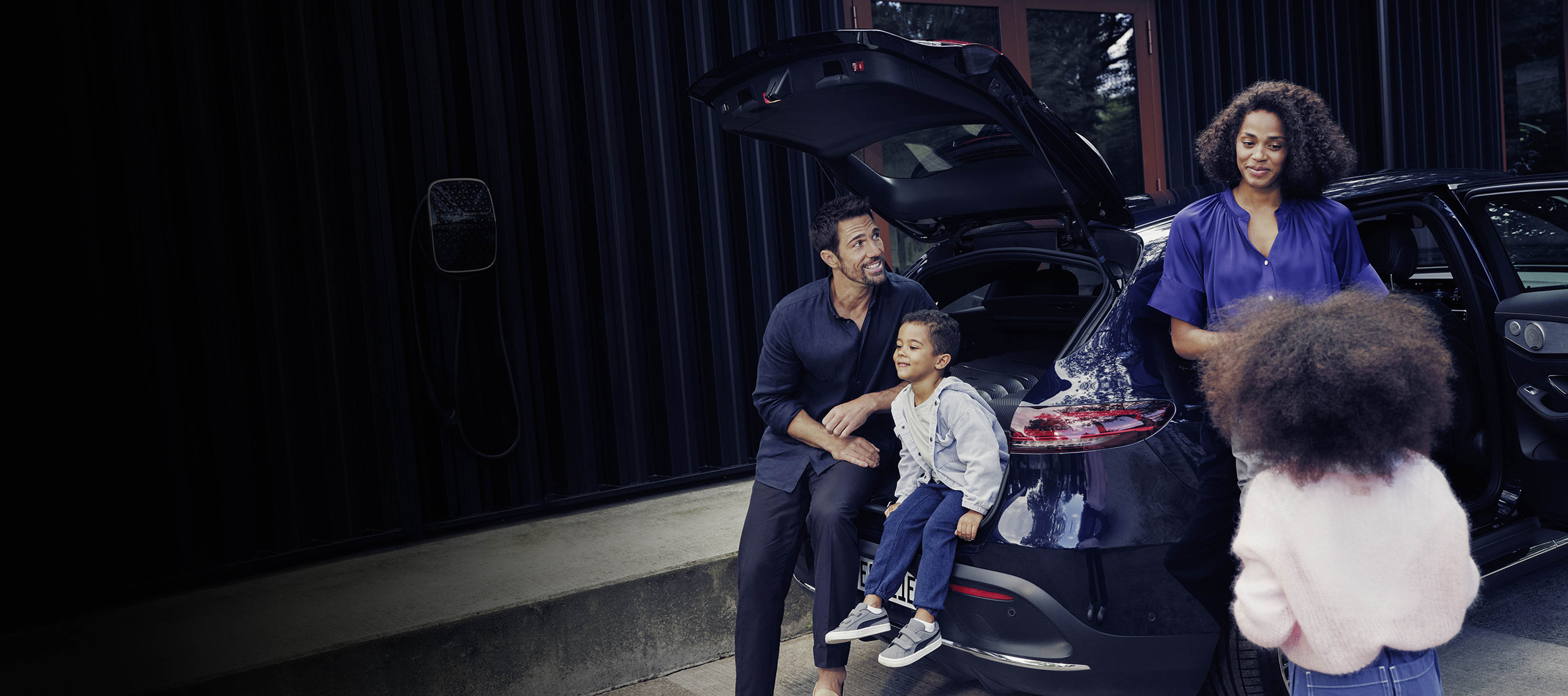 Insurance | Financial Services | Mercedes-Benz Family preparing their blue Mercedes-Benz EQC for a trip