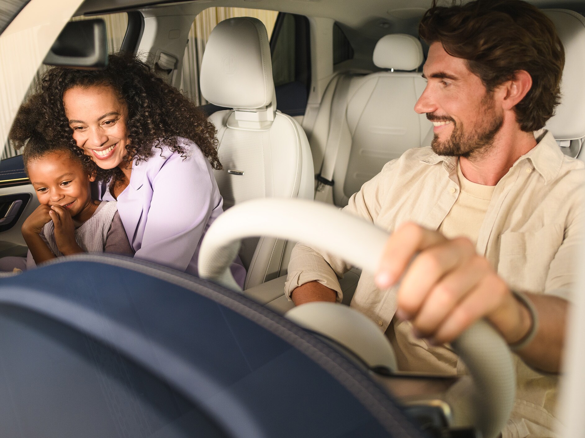 Two people and a child inside a Mercedes- Benz vehicle.