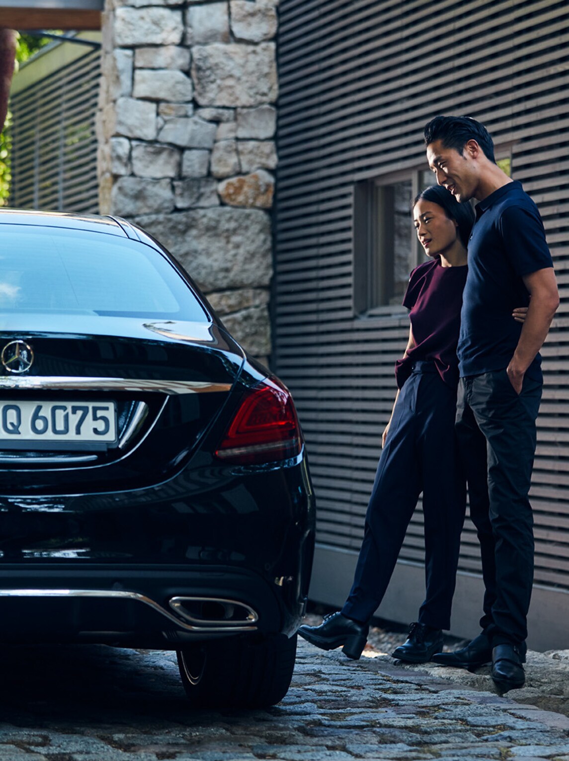 A couple stand next to the car they are financing