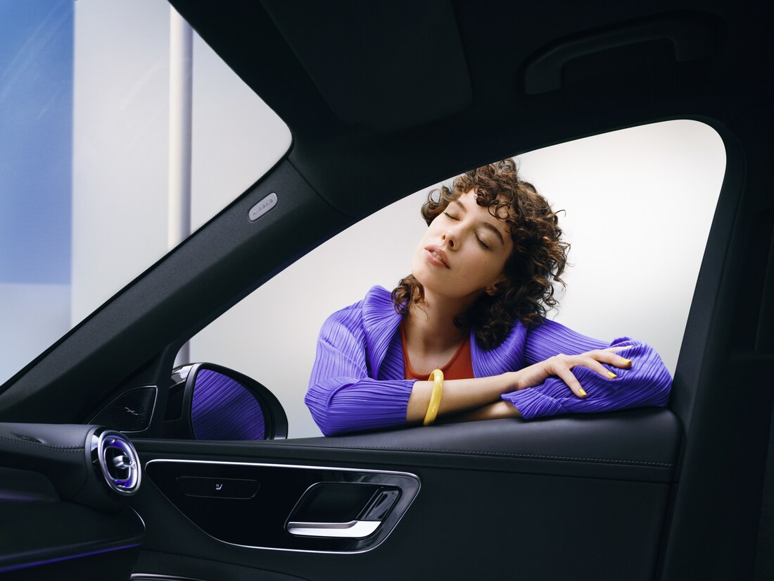 A woman enjoying looking at her clean Mercedes-Benz.