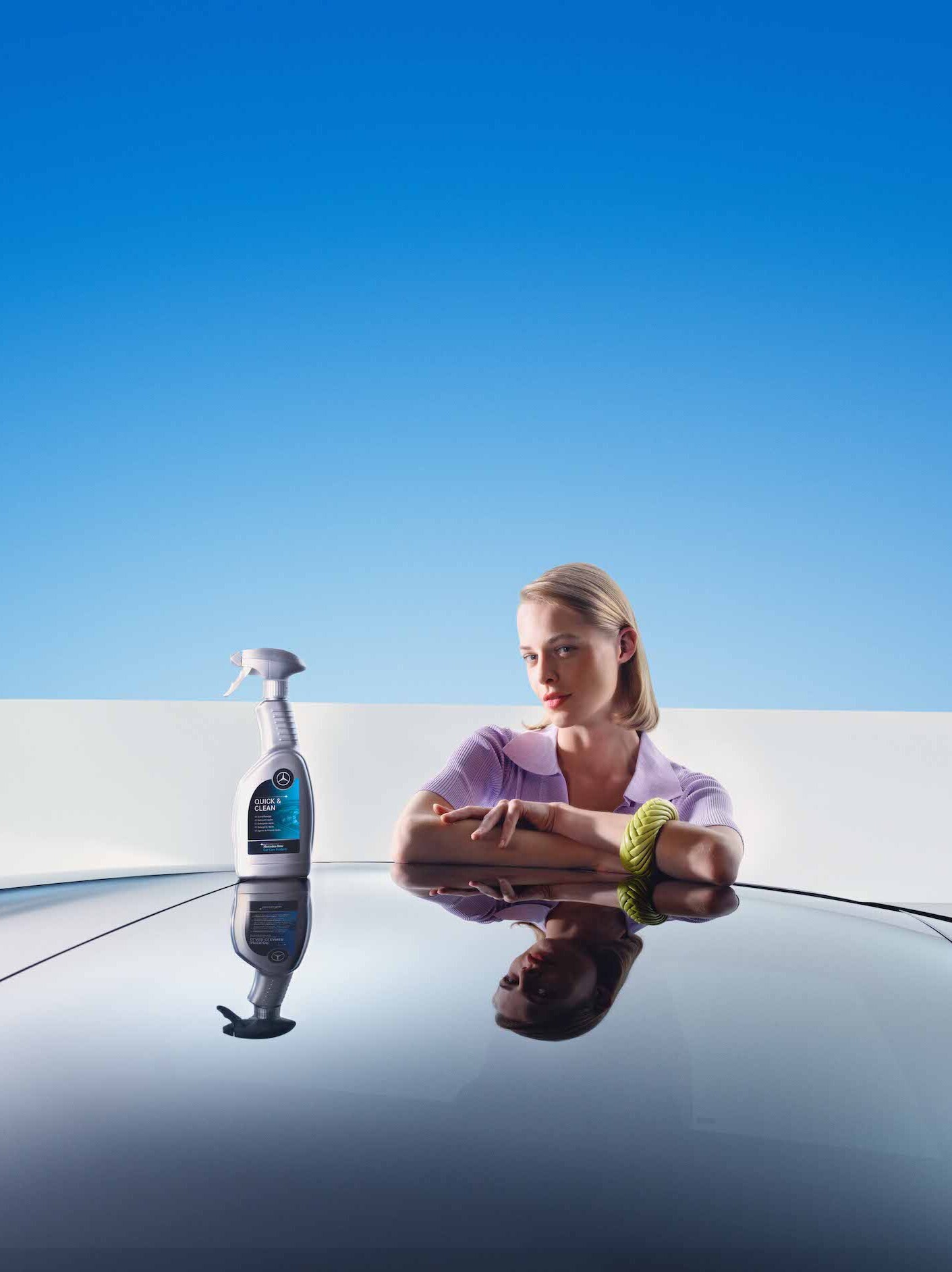 A woman leaning on her freshly cleaned Mercedes-Benz.