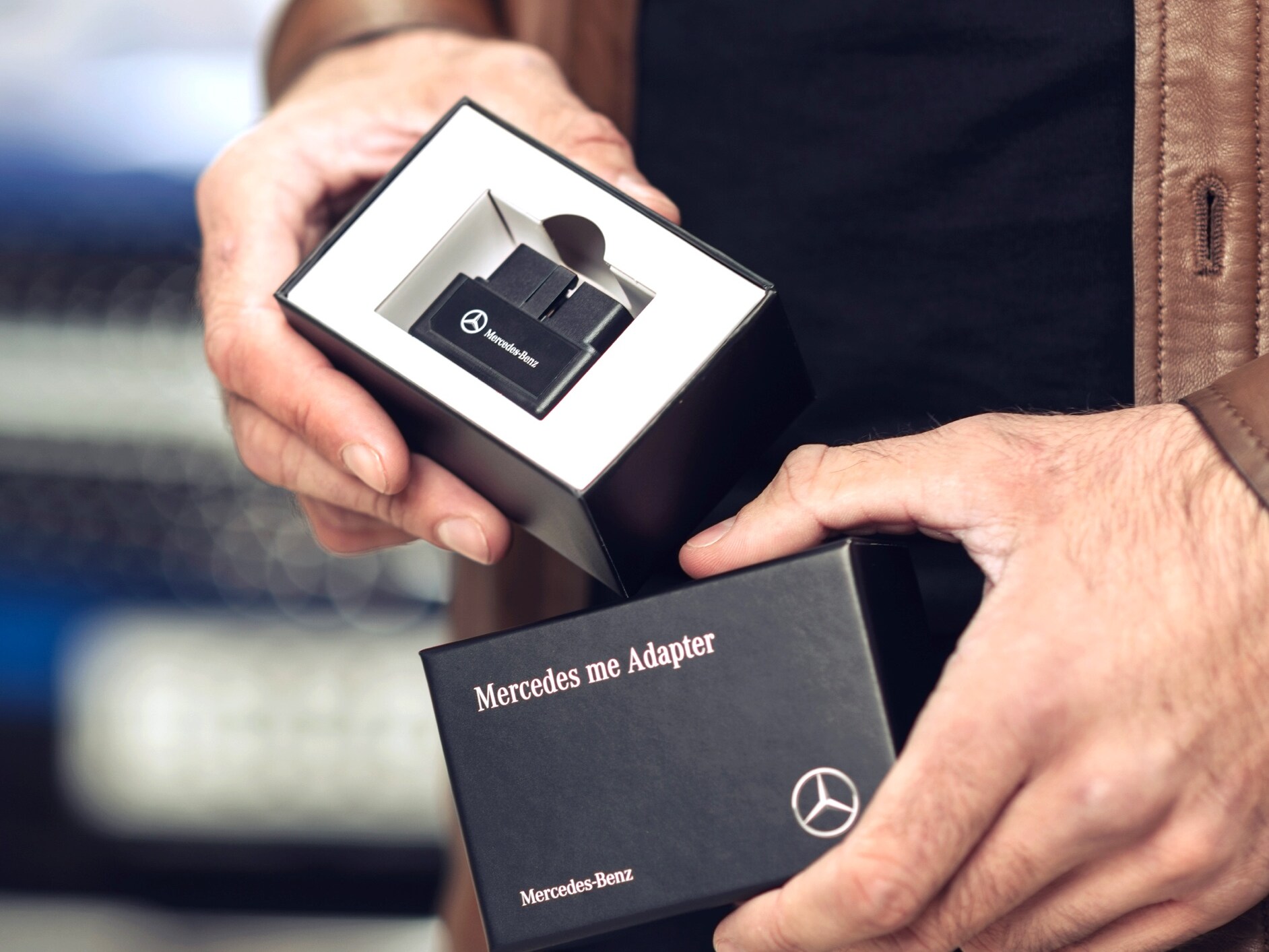 A man unpacks the Mercedes-Benz Adapter for his Mercedes-Benz to be able to use Digital Extras in his vehicle.