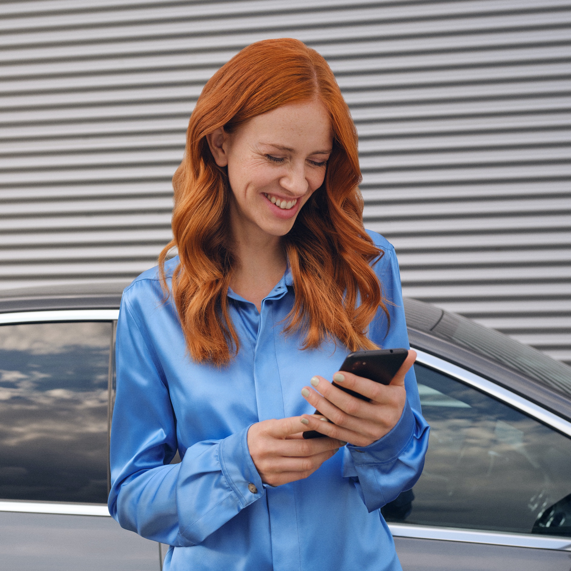 A woman connects to her Mercedes-Benz via the Mercedes-Benz App on her smartphone. A woman connects to her Mercedes-Benz via the Mercedes-Benz App on her smartphone.