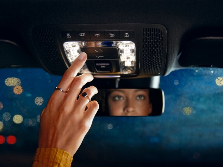A woman contacts Mercedes-Benz Customer Assistance at the touch of a button.