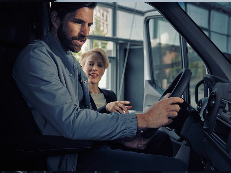 Man sitting in a Mercedes-Benz eSprinter talking to a dealer