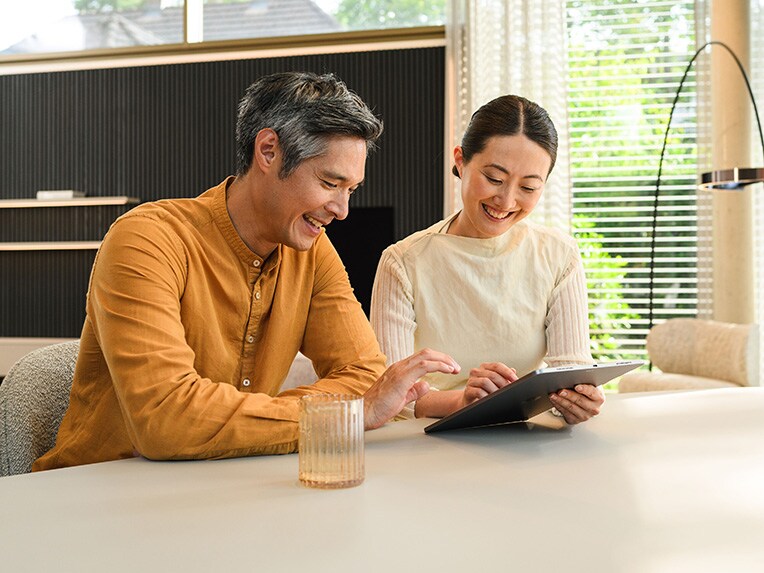 Two people sitting and looking at a mobile device.