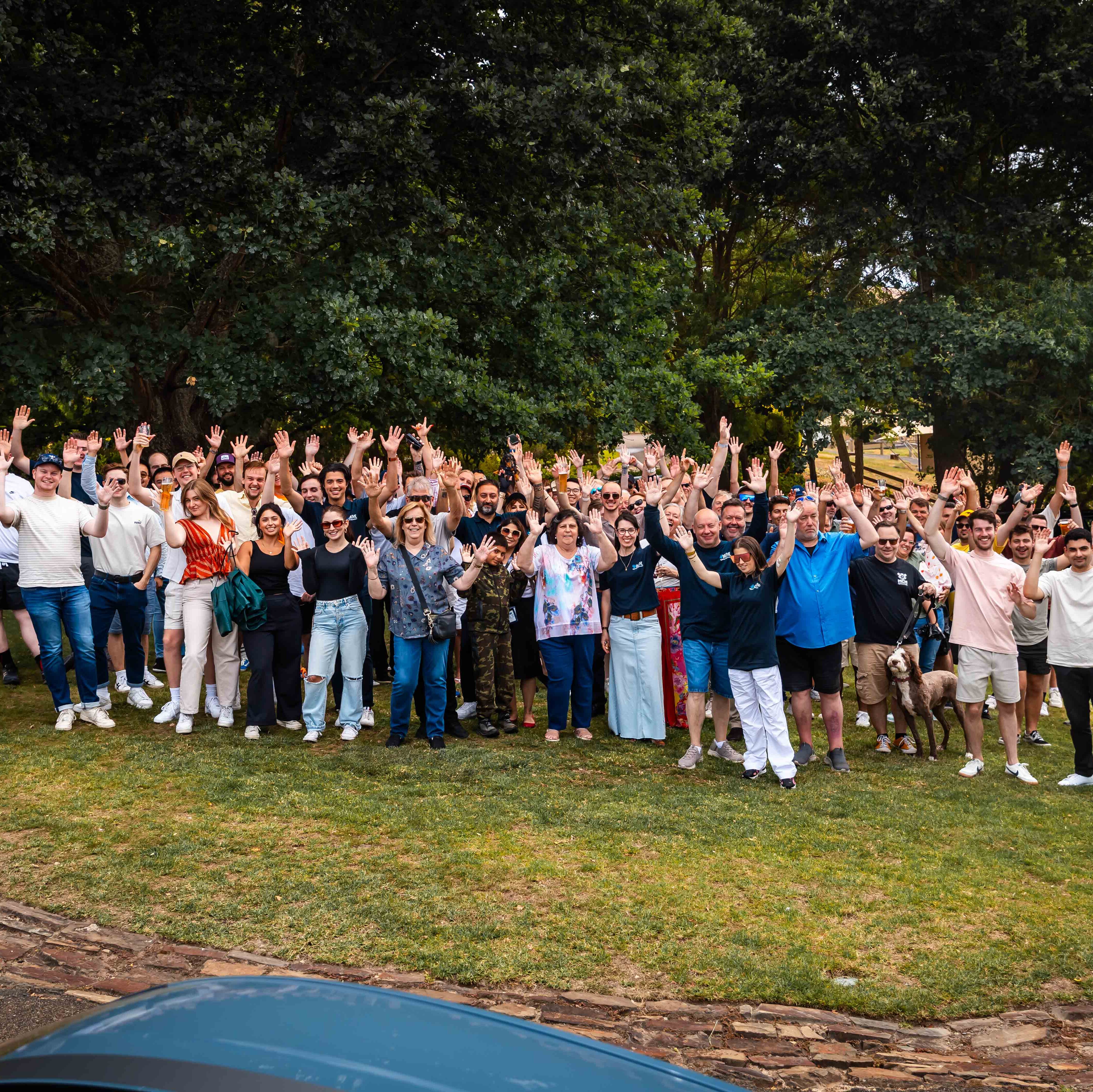 A large group of people with their hands in the air after a drive that advances mental health.