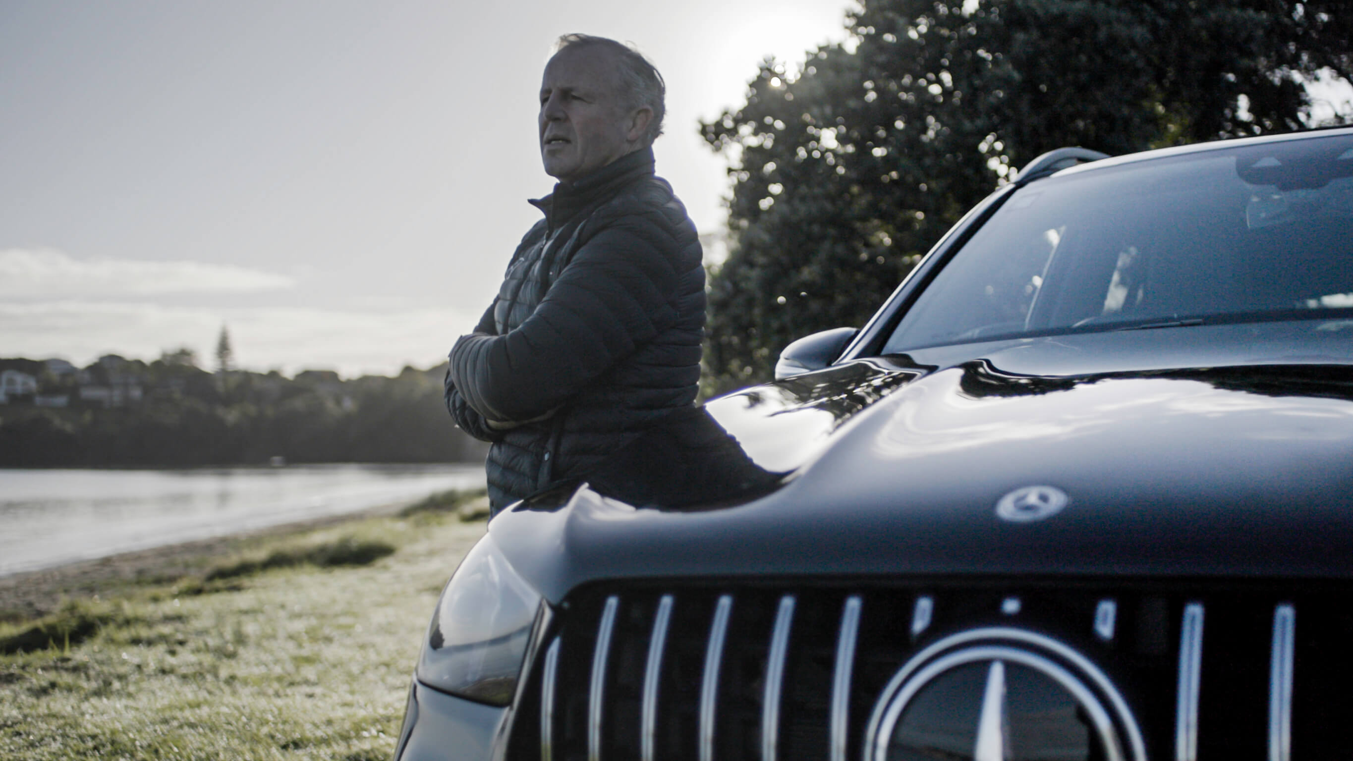 Sean Fitzpatrick Sean Fitzpatrick stands next to black Mercedes-Benz vehicle overlooking the water.